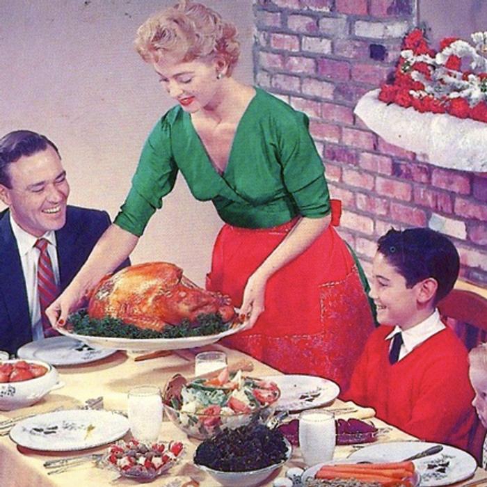 A 1960s family dinner table laden with food